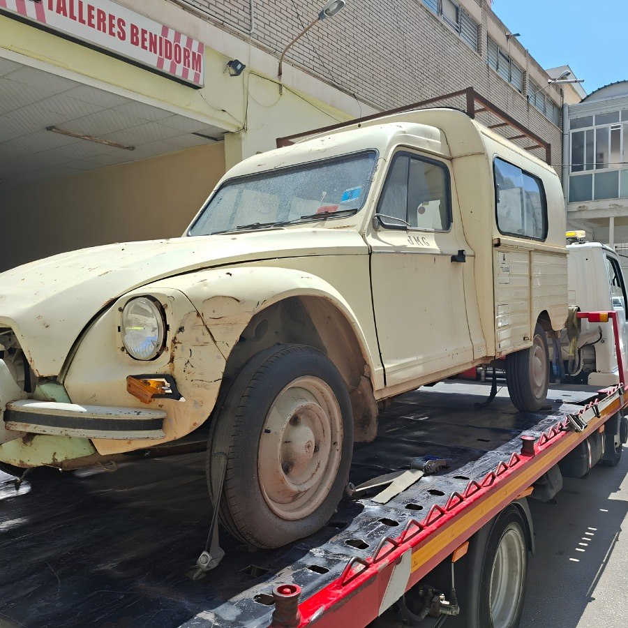 Vehículo clásico transportado sobre una plataforma de grúa